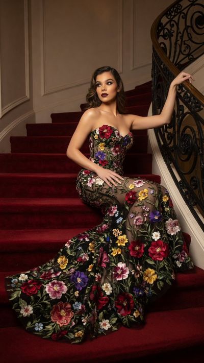 Hailee Steinfeld poses in floral black gown on grand staircase