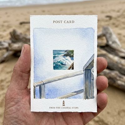 Hand Holds Watercolor Postcard of Coastal Steps by the Sea