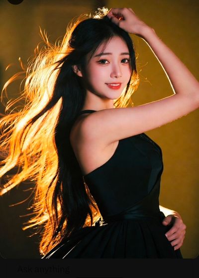 Golden rim light highlights elegant black dress and flowing hair