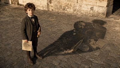 A young Jules Verne stands in harsh sunlight, his shadow aging