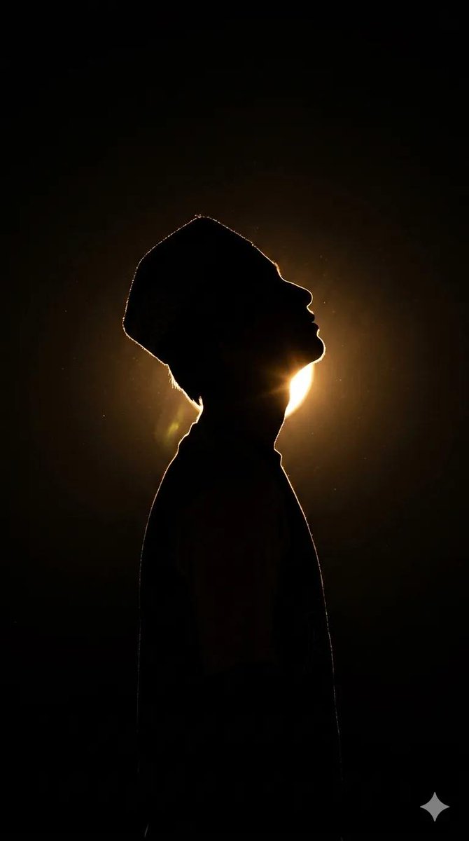 A lone man tilts his head back toward a warm glow