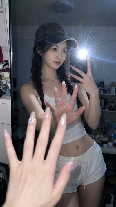 A woman takes a flash mirror selfie late at night in her bedroom.