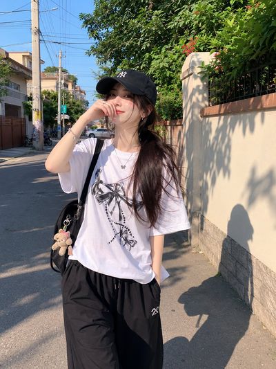 Japanese girl walks through sunny alley in casual streetwear