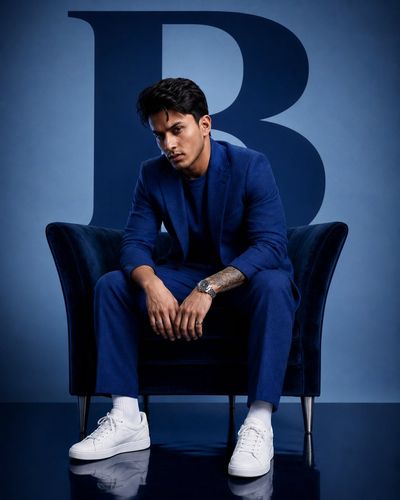 Confident businessman in blue suit poses in luxurious studio