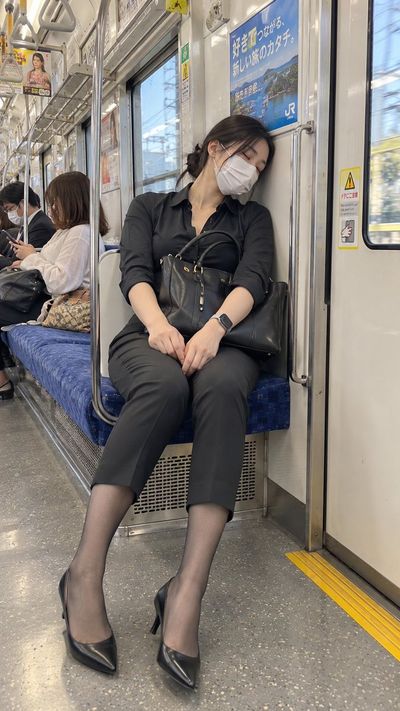 Exhausted commuter in black shirt sleeps on Japanese train seat