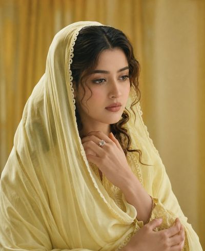 A woman in yellow attire radiates serene elegance and grace.