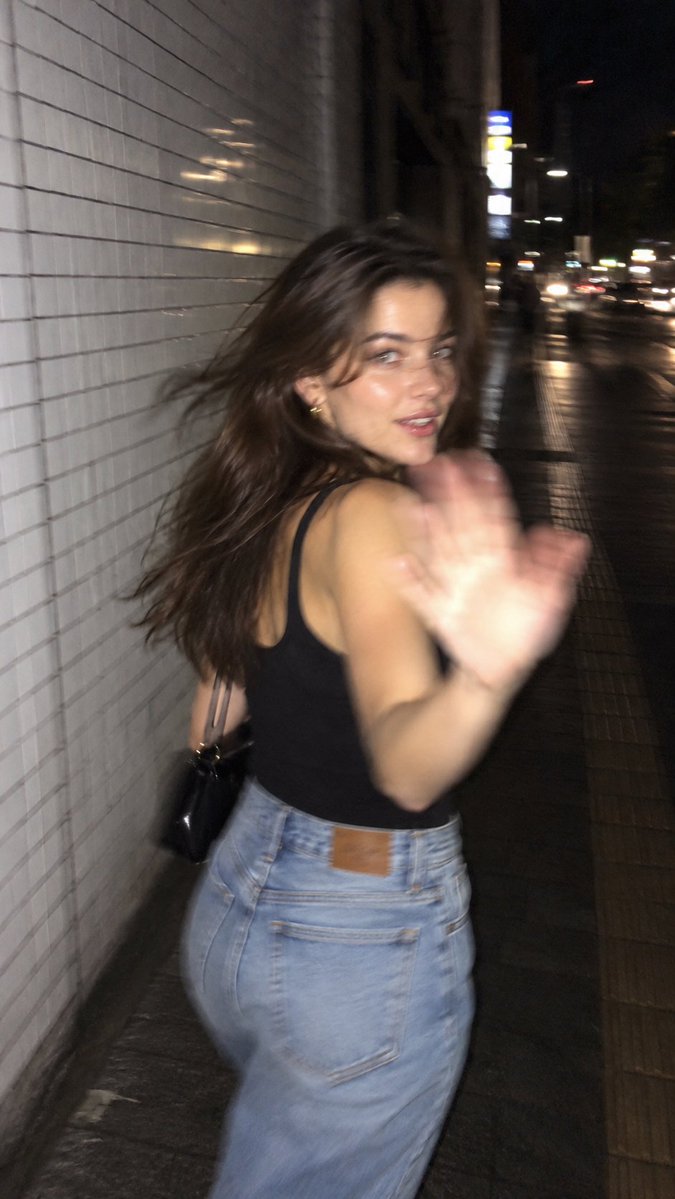 A girl turns back on a rainy Tokyo street at night