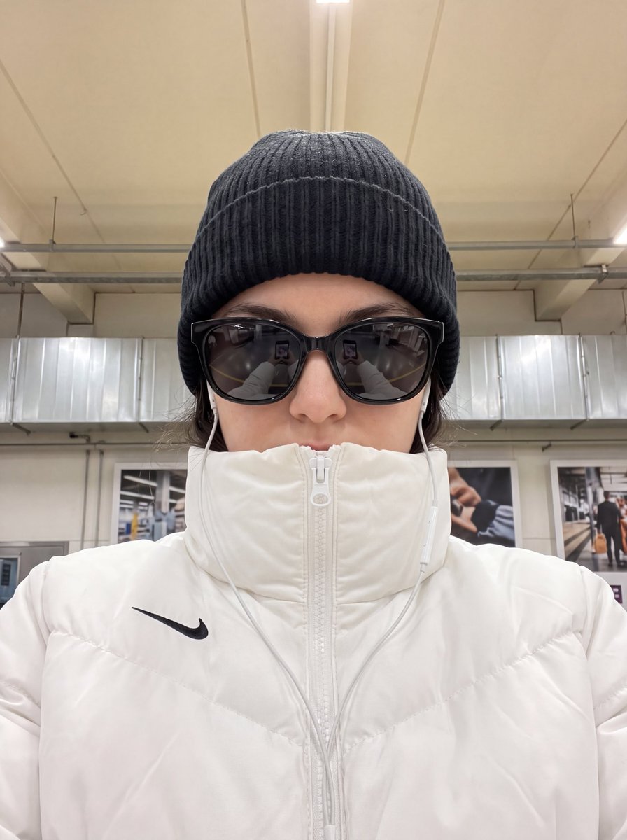 Close-up portrait of woman in black beanie and reflective sunglasses