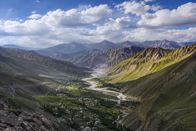 Golden sunlight illuminates a winding river through a lush mountain valley