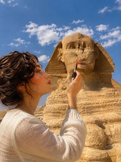 Woman applies lipstick to Great Sphinx in forced perspective