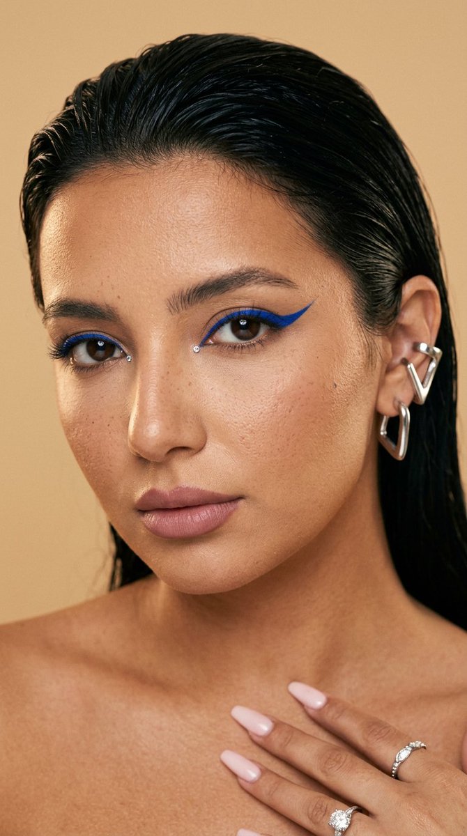 Woman with cobalt graphic liner stares intensely into the lens