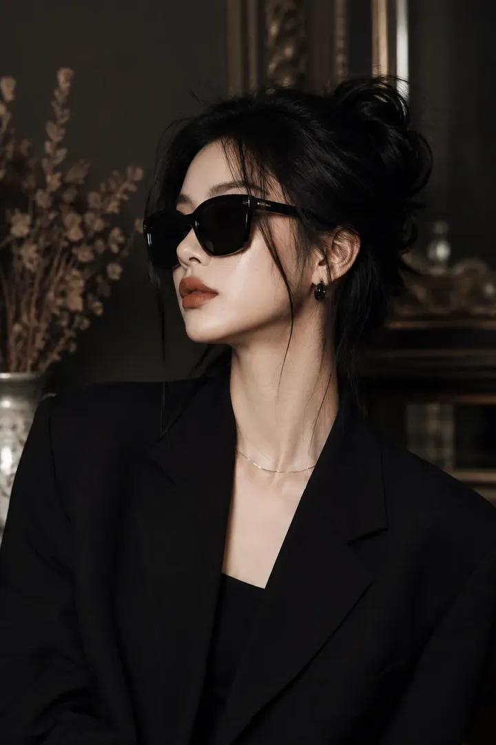 A young woman in a black blazer poses with a mysterious gaze