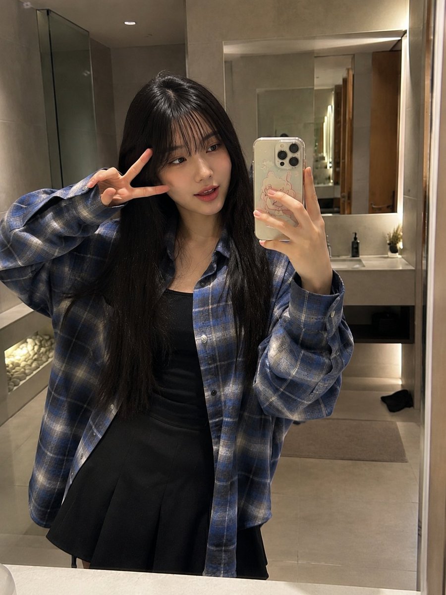 Japanese woman takes a casual mirror selfie in a blue flannel shirt