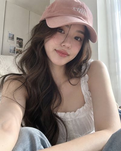 Soft Window Light Captures Young Woman in Pink Cap
