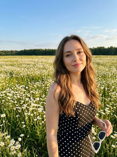 Sun-Kissed Woman in Polka Dot Dress Amid Daisies