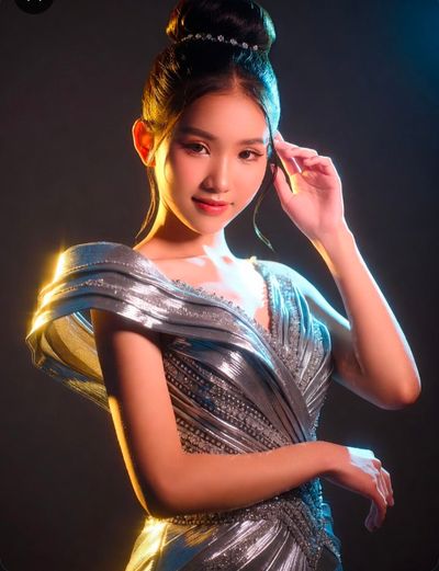 Silver gowns glow under dramatic rim lighting in studio portraits
