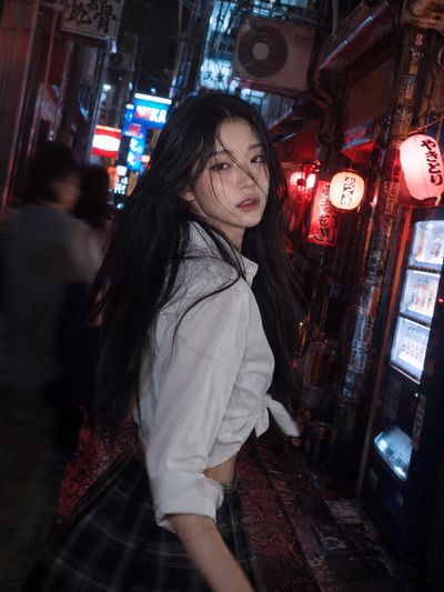 A startled woman rushes through a neon-lit Tokyo alley at midnight