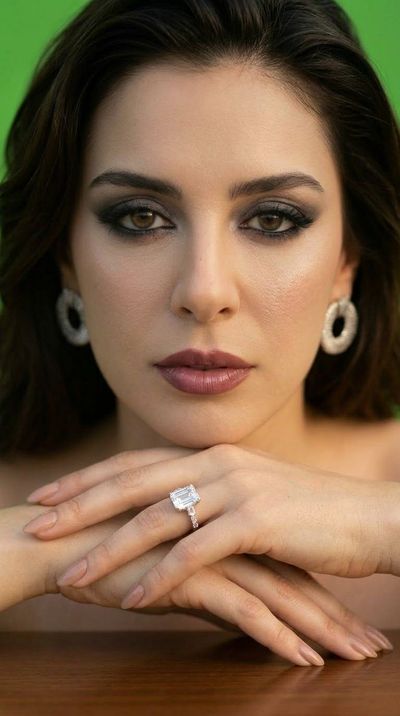 Stunning Woman Wearing Emerald Diamond Ring in Studio Portrait