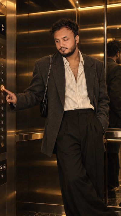 Man in Tailored Blazer Presses Elevator Button in Golden Light