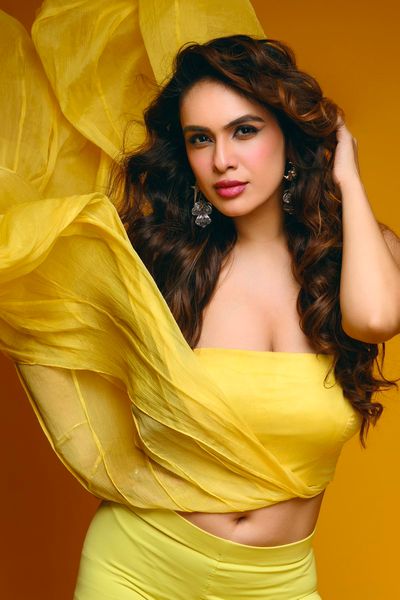 Indian model in yellow skirt and crop top poses confidently