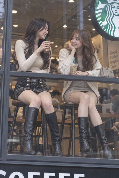 Two Friends Share Laughter Through a Coffee Shop Window