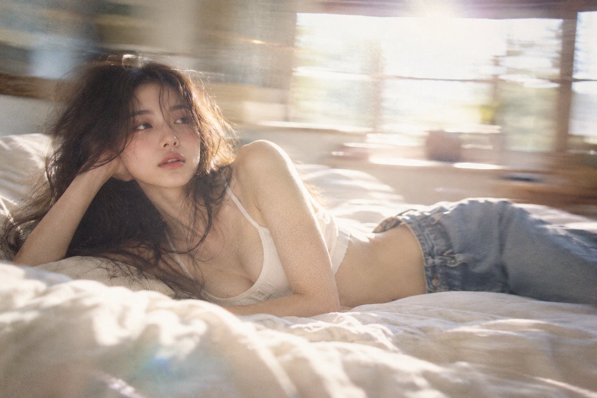 Sunlit bedroom scene with woman lying on bed, motion blur