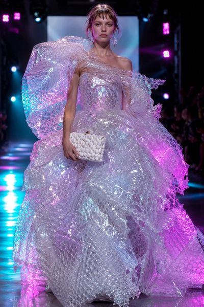 Iridescent bubble wrap gown gleams under neon runway lights