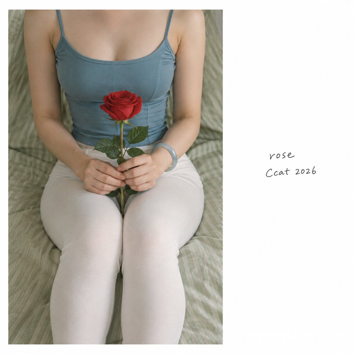 Seated woman in blue camisole holds a red rose gently