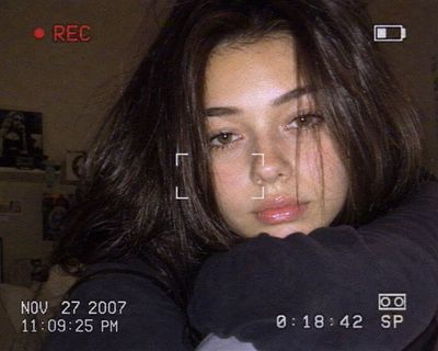 A woman rests her face on sweater arms in warm dim light