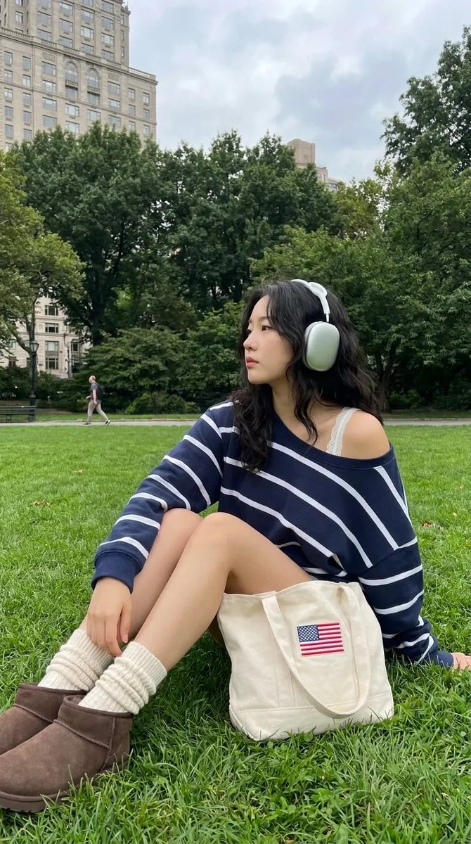 Korean woman listens to music in Central Park with headphones