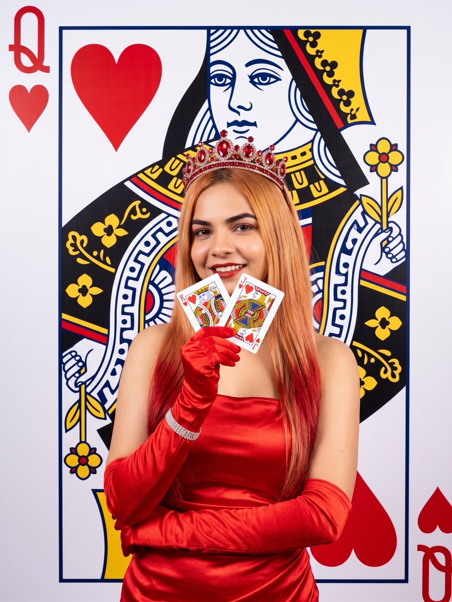 Smiling Woman in Ruby Crown Holds Winning Heart Cards