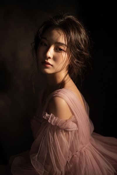 Elegant East Asian Woman in Tulle Gown Softly Lit