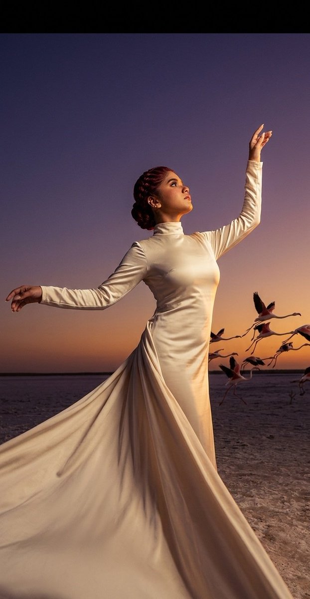 Silk-clad dancer pirouettes on mirrored salt lake at sunset