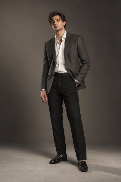 British male model poses in charcoal blazer under studio lighting