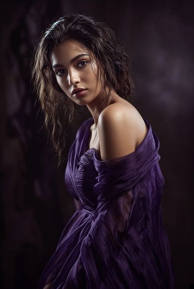 Woman in Purple Gown Gazes Dramatically in Studio Light