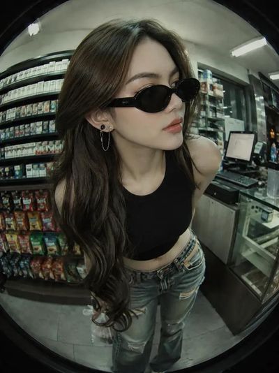 A woman leans forward in a minimarket with neon lights