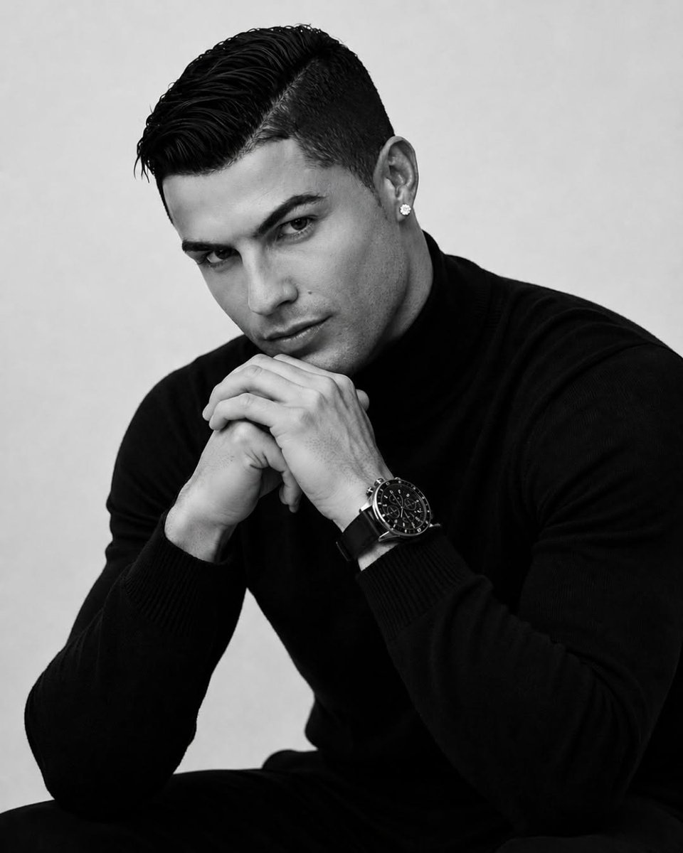 Athletic man in black turtleneck poses for dramatic monochrome portrait.