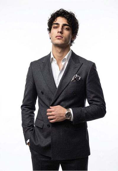 A confident executive adjusts his blazer lapel in studio light