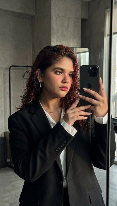 Sleek Confidence: A Mirror Selfie in a Dark Minimalist Studio