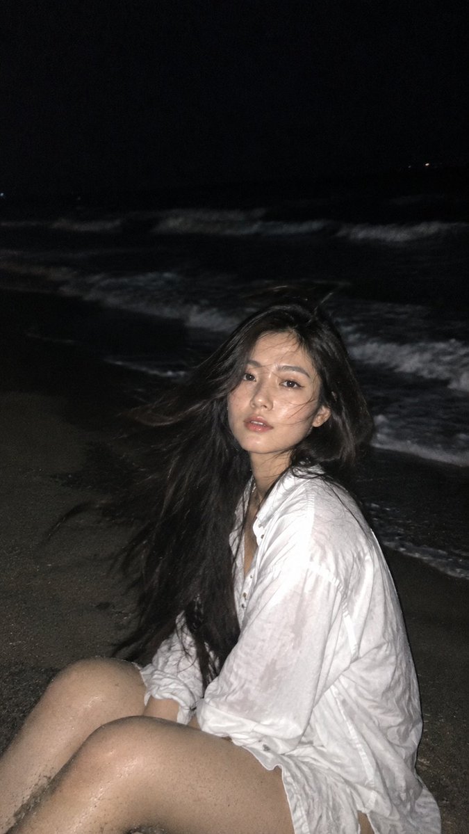 Candid Night Beach Portrait of Woman Brushing Windblown Hair