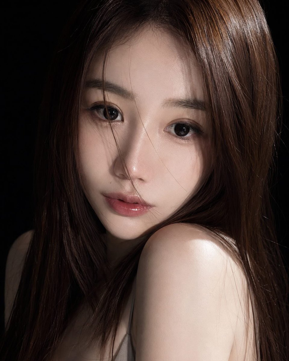 A young East Asian woman with glossy pink lips gazes melancholically.