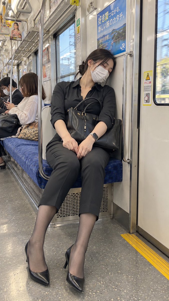Exhausted commuter in black shirt sleeps on Japanese train seat