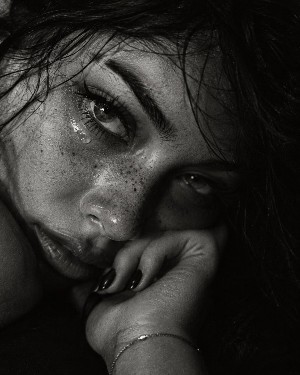Intimate Black and White Portrait Captures Woman's Tearful Gaze in Shadow