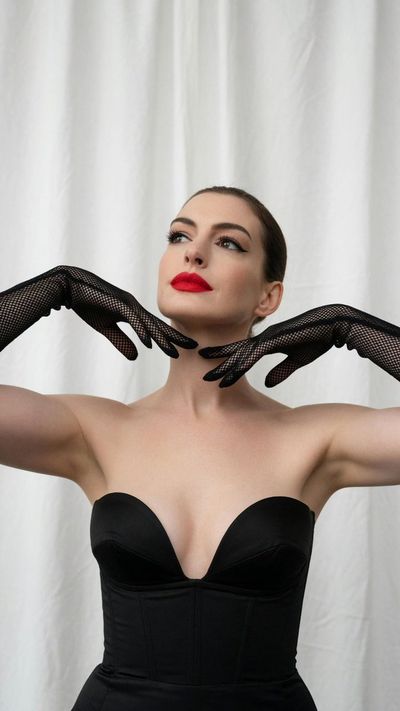 Anne Hathaway poses with white fishnet gloves in studio light