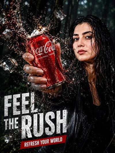 Model holds crushed cola can amid splash in dark forest