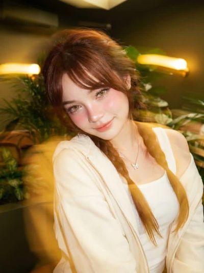 Young woman in cozy café with tropical plants and soft lighting