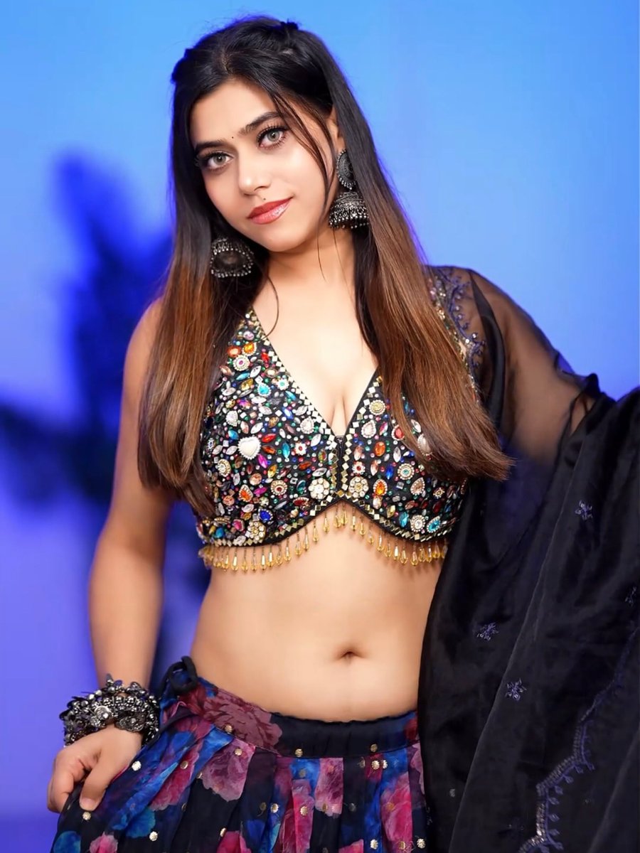 Indian model in ornate mirror-work blouse poses with confident allure