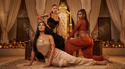 Three fashion muses command a golden throne in a Marrakesh riad.