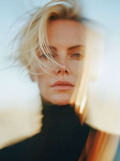 Charlize Theron stands in cinematic light and motion scene