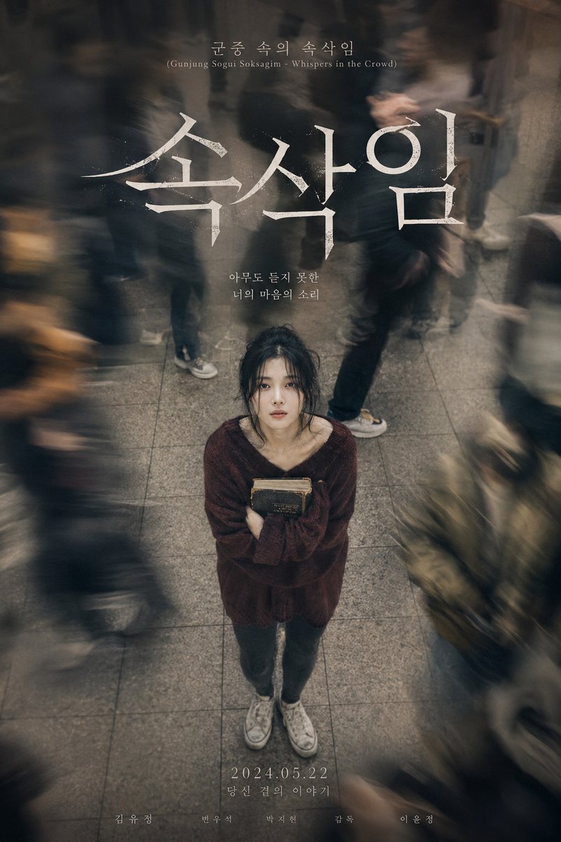 A lonely woman clutches a novel while commuters blur past her.
